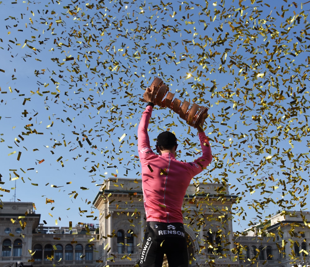 Câștigătorul competiției ridică cupa spre cer în timp ce o ploaie de confetti zboară în aer.