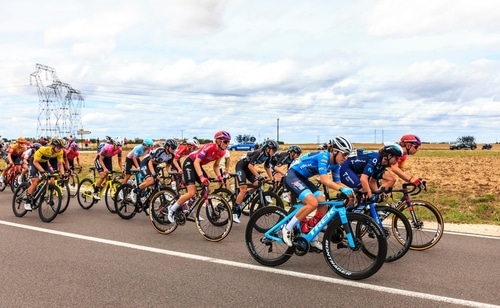 En gruppe kvindelige cyklister kører om kap på vejen. 